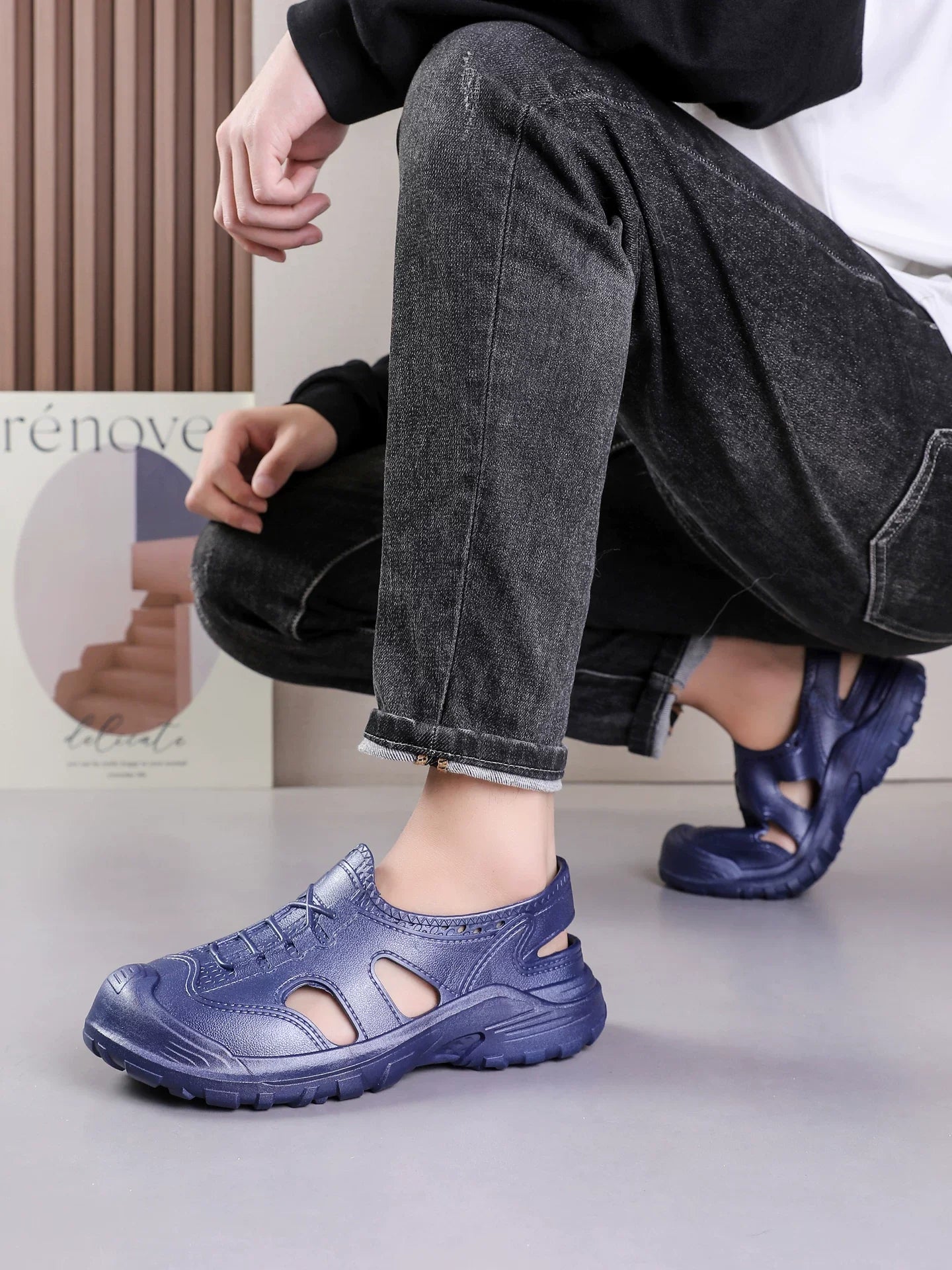 Marineblå sneaker på fod med grå denim jeans, lifestyle-billede — Nordleva