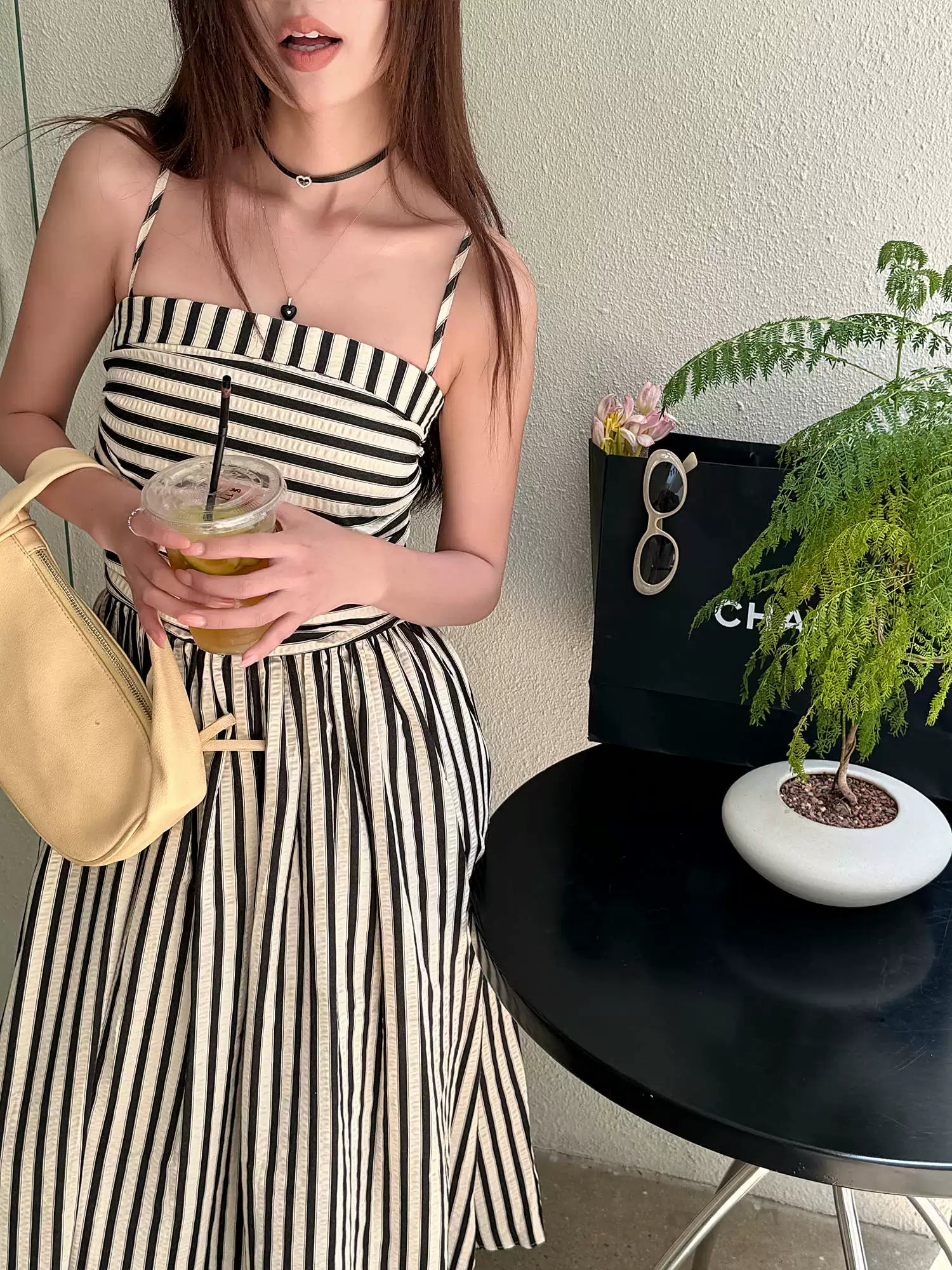 Sort og beige stribet maxikjole bust-detalje ved cafébord — Nordleva