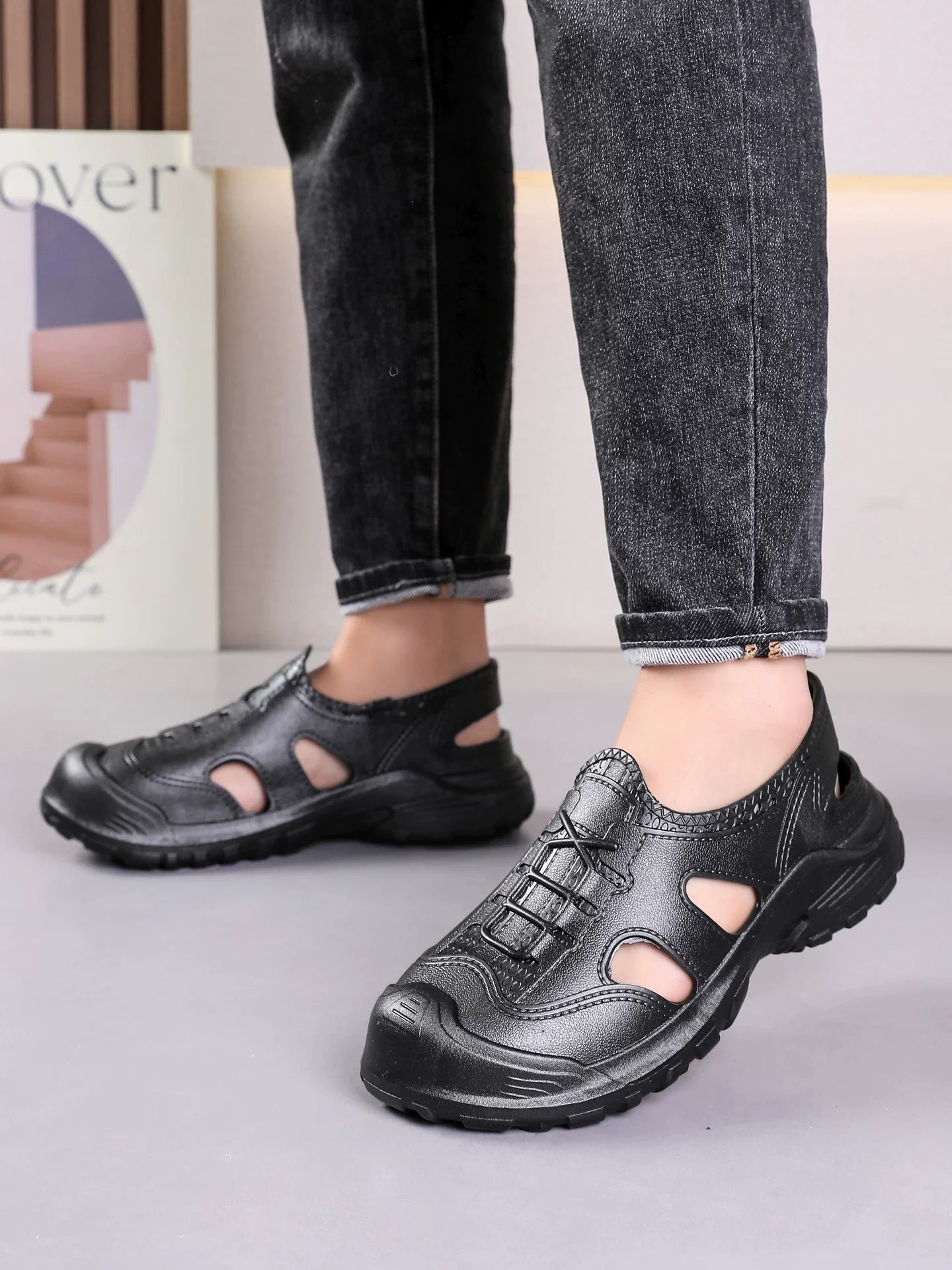 Sort læderlook sneaker på fod med chunky sål og perforerede udskæringer — Nordleva