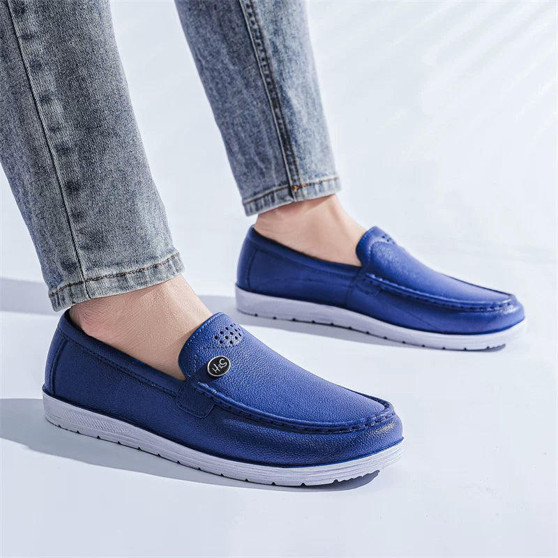 Marineblå perforeret loafer på fod med jeans — Nordleva
