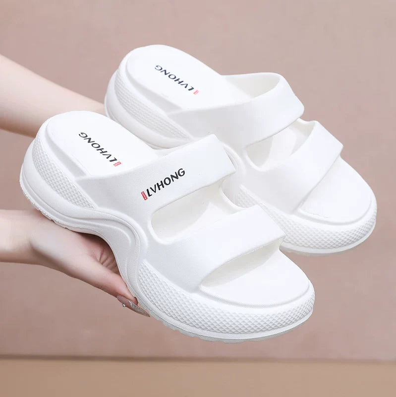 Hvide slip-on sandaler med dobbelte remme og kilehæl set oppefra — Nordleva